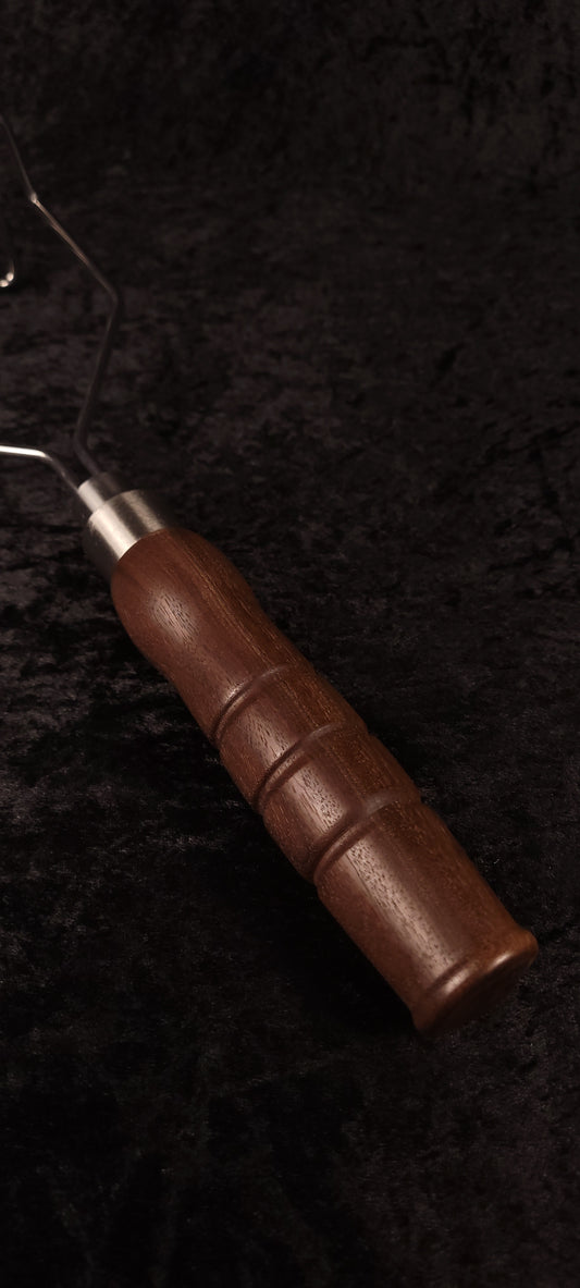 Handcrafted walnut potato masher top-down view showing wire head