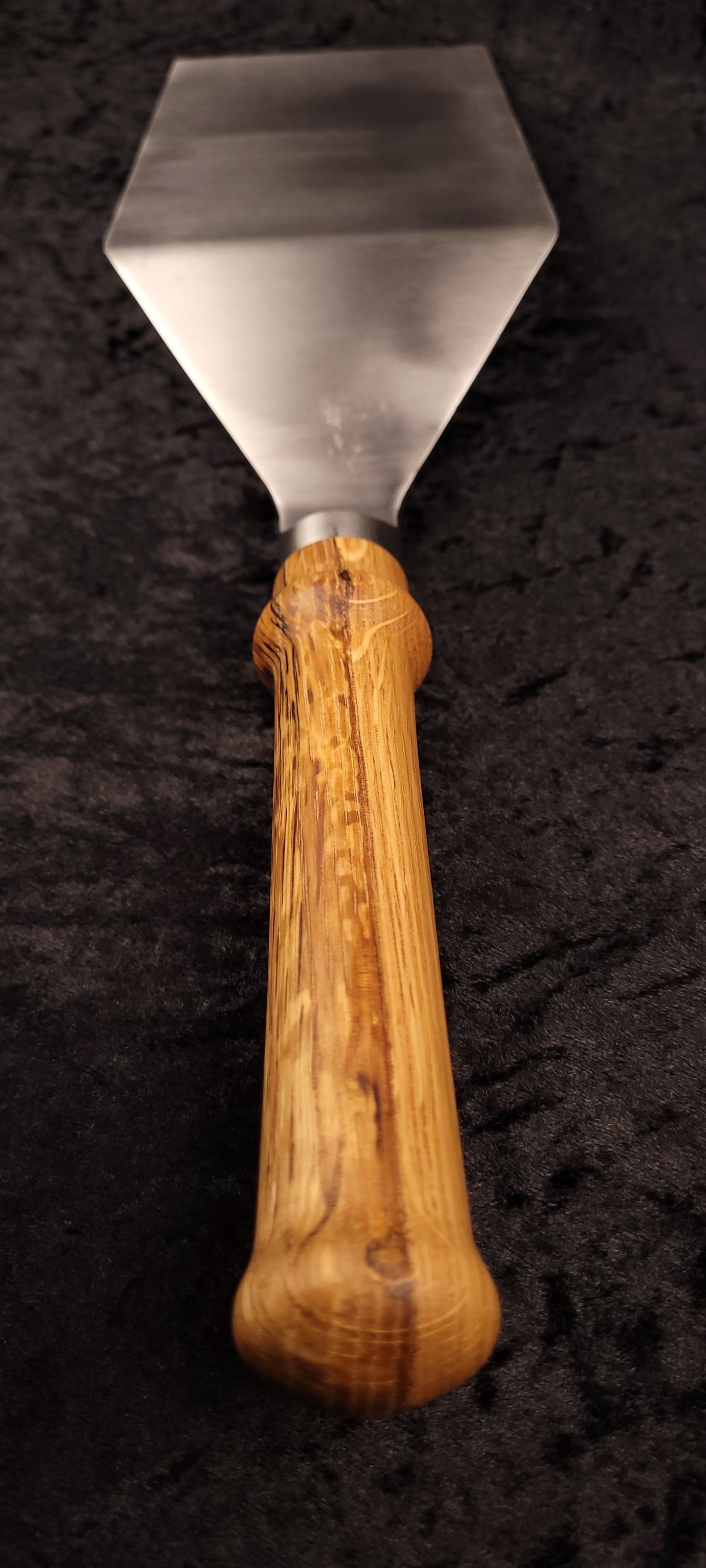 Griddle spatula oak handle – side angle with log