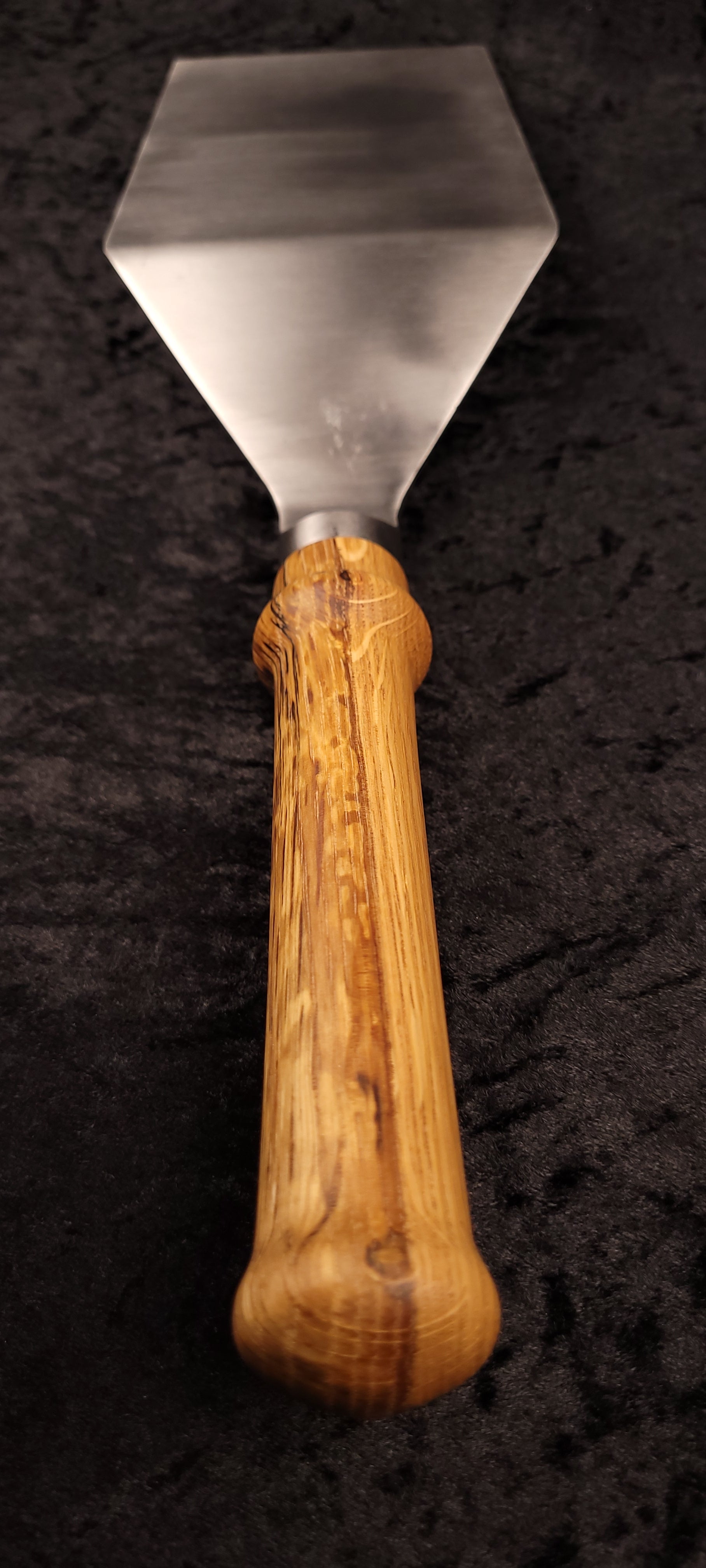 Griddle spatula oak handle – side angle with log