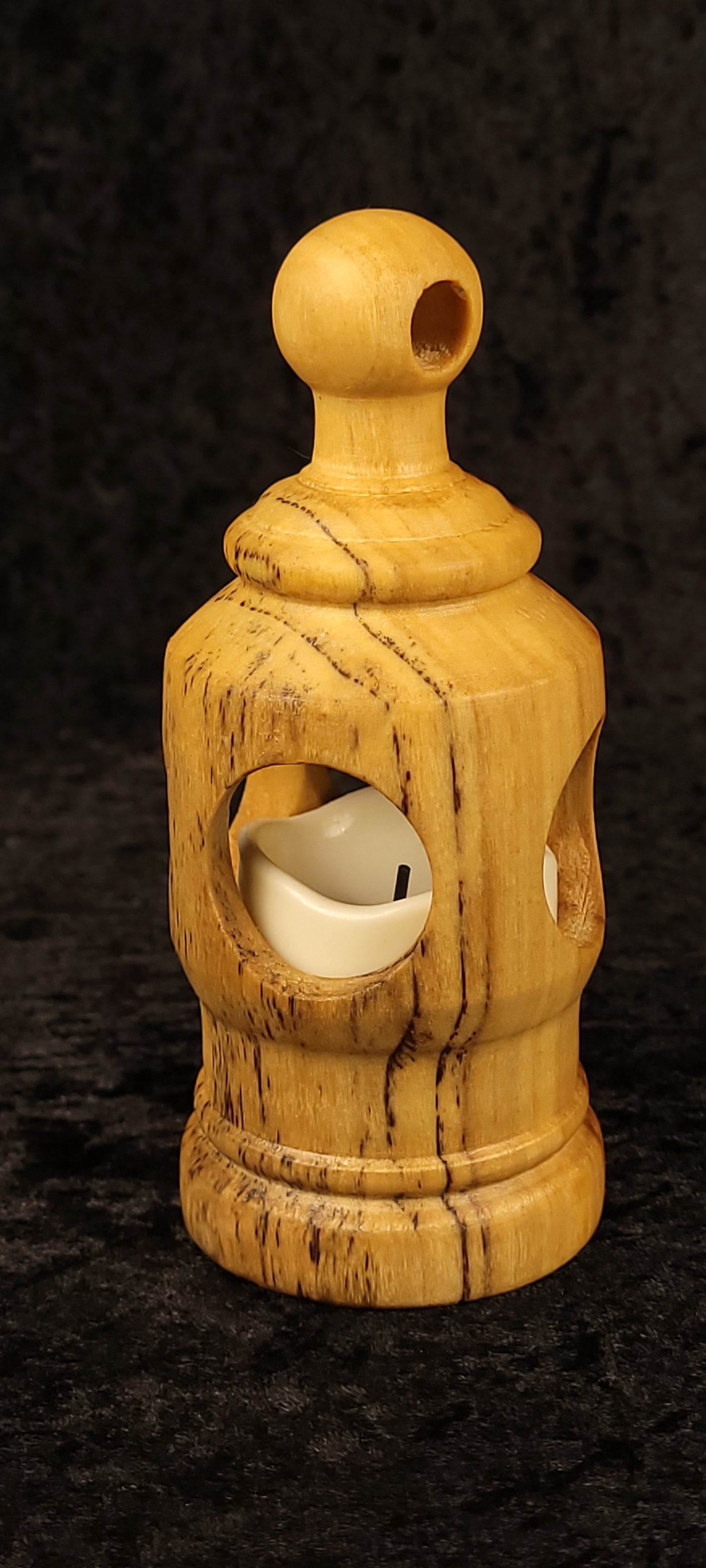 Handcrafted cottonwood votive lantern glowing with LED candle - front view