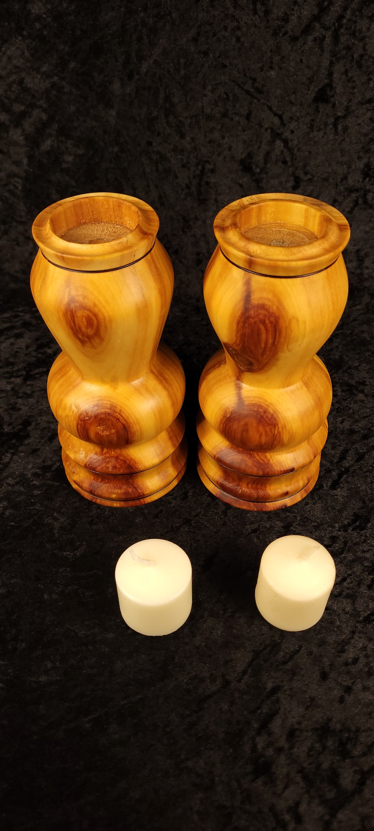 One aspen candle holder standing, one on its side - showing base and candle cup detail
